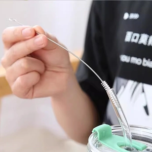 Nylon bristle cleaning brush for stainless steel straws and bottles shown in use