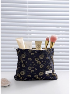 Navy blue daisy canvas cosmetic bag with gold floral patterns and zipper closure