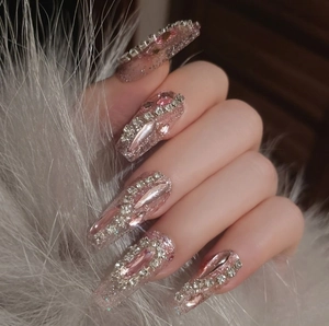 Pink glitter press-on nails in long coffin shape with V-shaped pink and silver rhinestones
