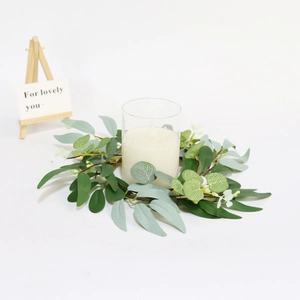 Close-up of 30cm eucalyptus candle ring with faux willow leaves and a white pillar candle