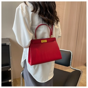 Detail of red leather bridal handbag with golden lock and adjustable shoulder strap
