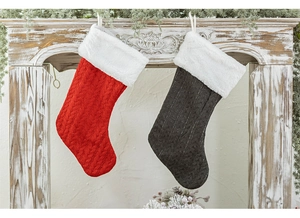 Detail of red and grey knitted Christmas stockings with faux fur cuffs on a fireplace