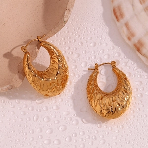 Detail of 18K gold plated oval hoop earrings with vintage embossed geometric patterns