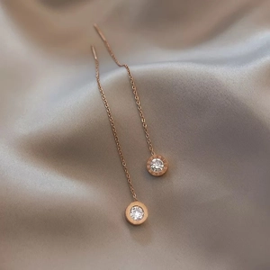 Rose gold Roman numeral long threader earrings with zircon stone on silk background