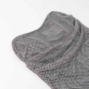 Détail du tissu en résille argentée avec strass scintillants sur une mini robe sexy