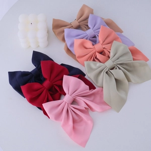 Detail of 7 colorful fabric hair clips with long ribbon tails and delicate texture