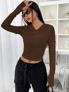 Eng anliegendes braunes langärmliges Kapuzen-Crop-Top kombiniert mit schwarzer Cargo-Hose für Damen