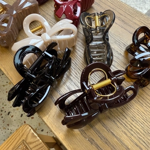 Close-up of assorted large butterfly hair claws on a warm wooden background