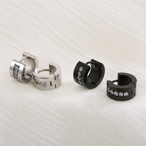 Macro detail of silver and black stainless steel hoop earrings with white zircon inlays