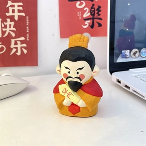 Macro detail of hand-carved God of Wealth figurine with golden wealth scroll on desk