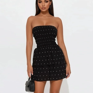 Nahaufnahme von schwarzem schulterfreiem Polka-Dot-Kleid mit Rüschen und Handtasche