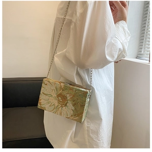 Detailed view of sunflower embroidery on a luxury chain crossbody bag with metallic clasp
