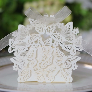 Close-up of white laser-cut butterfly favor box with elegant organza ribbon bow detail