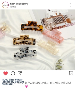 Detail showing five assorted acetate hair clips with leopard and marble patterns on silk