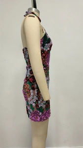 Détail de la broderie de fleurs à paillettes multicolores sur la robe dos nu