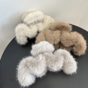 Detailed view of plush faux fur hair claws in beige, khaki, and light grey colors