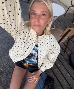 Detailed view of women polka dot jacket with zipper and metal button accents