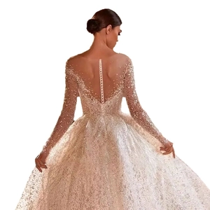 Luxury long sleeve bridal gown with sequins, deep V-back design, and sparkling champagne tulle