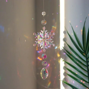 Snowflake crystal suncatcher with AB colored prisms hanging as Christmas window decoration