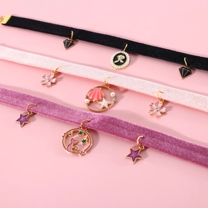 Detail of velvet pet collars in black, pink, and purple with golden metal pendants