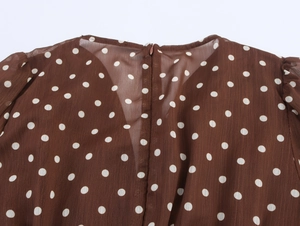 Détail du dos d'une robe en mousseline marron à pois avec fermeture éclair invisible