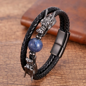Detail of dragon head charms on black braided leather bracelet with blue stone bead