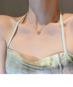 Detailed view of champagne gold crown pendant with sparkling round-cut zircon on necklace