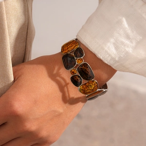 Detail of amber resin geometric stretch bracelet with vintage silver metal frame on wrist
