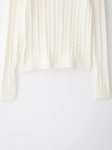 Detail of cable-knit texture and ribbed hem on ivory white knitwear sweater cardigan