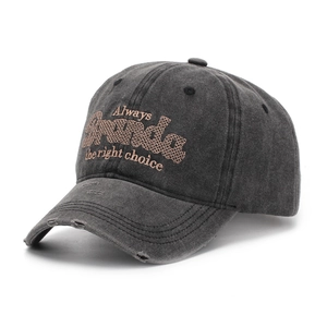 Detail of washed black baseball cap featuring distressed fabric and letter embroidery