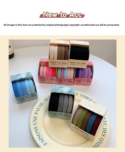 Close-up of high-elasticity colorful hair ties in various shades on a textured dish
