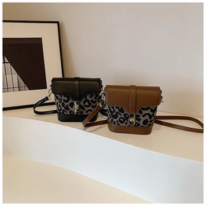Detail of leopard print bucket bag with leather flap and metal buckle closure