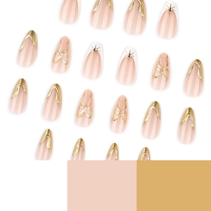 French 3D gold almond press-on nails with nude pink base, metallic bows and star designs