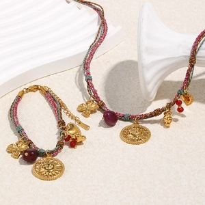 Detail of 18K gold-plated sun pendant on multi-color woven cord necklace and bracelet