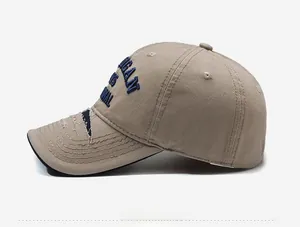 Close-up of distressed brim and blue 3D embroidery on beige vintage baseball cap