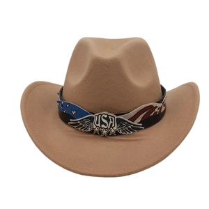 Detail of light brown cowboy hat featuring silver USA eagle emblem and star stripe band