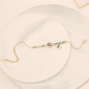 Detail showing golden fish charm and turquoise beads on adjustable chain bracelet