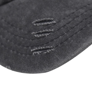 Gros plan de la visière de casquette grise vieillie avec triple couture et déchirures