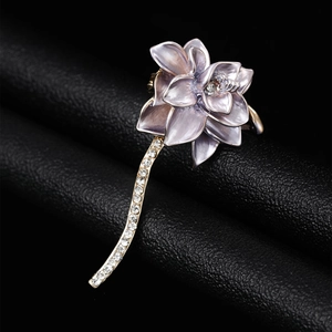 Macro detail of a purple lotus brooch with golden stem and sparkling rhinestones