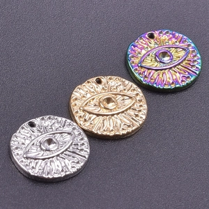 Three evil eye pendants in gold, silver, and rainbow colors with a polished metal finish