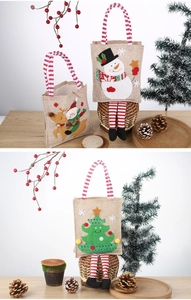 Detailed view of burlap Christmas bags with embroidered snowman and reindeer designs