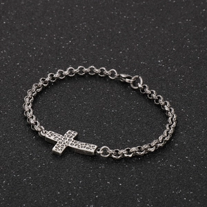 Detail of vintage silver titanium steel bracelet with hammered texture cross pendant
