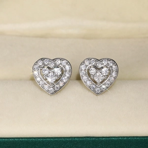 Macro shot of silver heart stud earrings with pave zircon and princess cut center stone