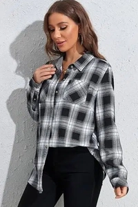 Close-up of black and white plaid flannel fabric with pocket detail and button closure