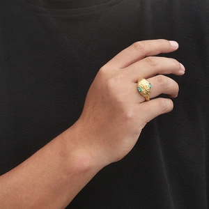 Detailed view of punk snake head ring with green eyes on a hand for men