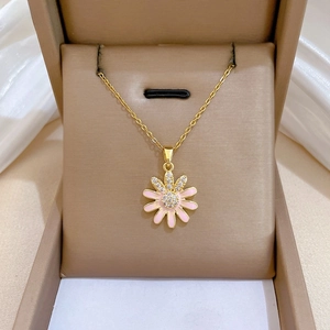 Detail view of a pink enamel daisy pendant with zircon stones on a gold-plated O-chain