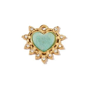 Dettaglio pendente a cuore con pietra verde, bordo dorato a raggiera e gemme