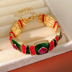 Macro shot of vintage style metal bracelet with red beads and colorful enamel in jewelry box