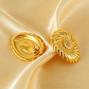 Détail de boucles d'oreilles fleur plaquées or 18K avec zircons sur satin doré plissé