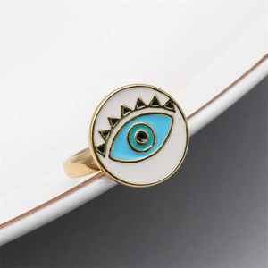 Macro detail of golden evil eye ring featuring blue and white enamel drip oil craft